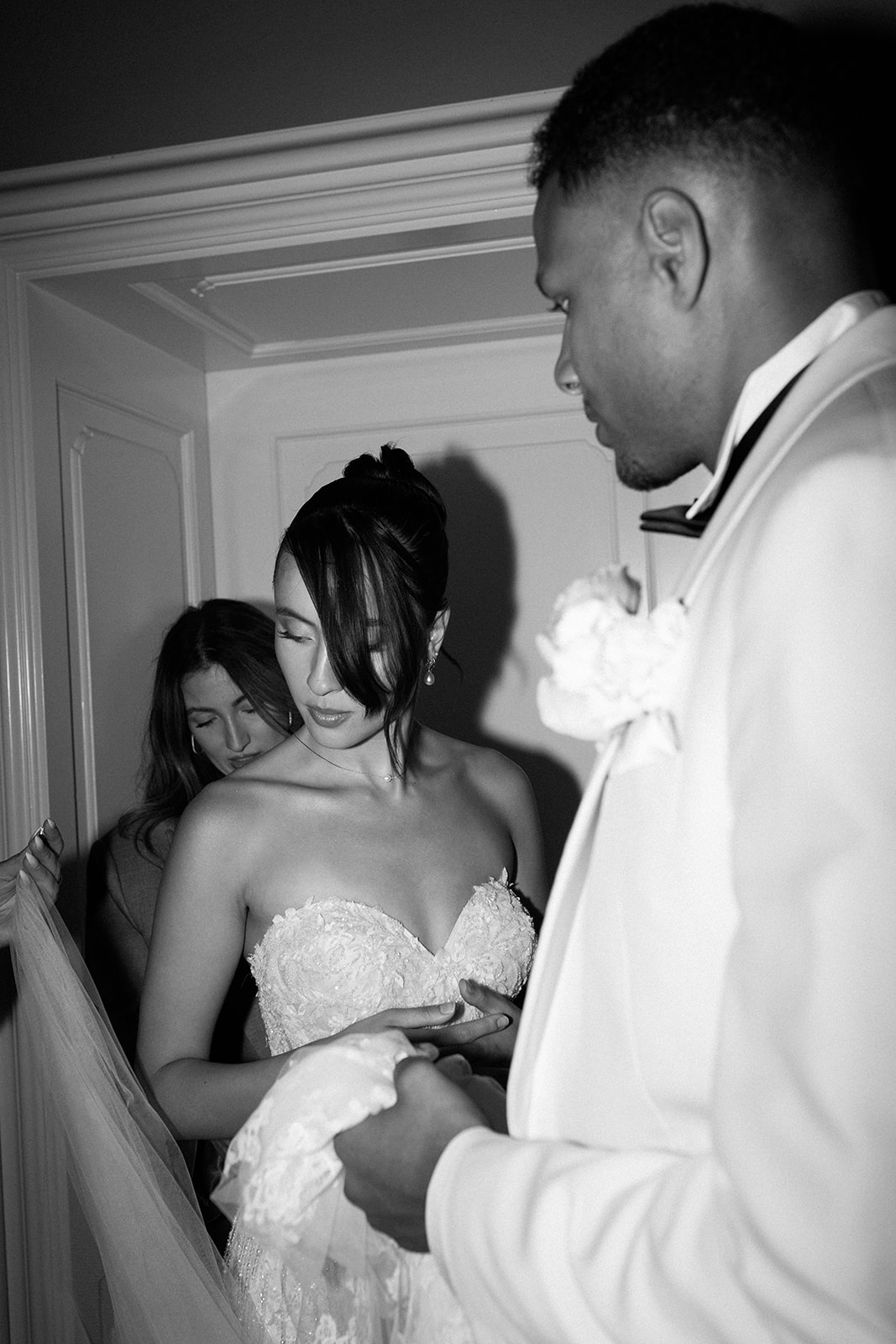 Braut richtet ihren Schneider mit Bräutigam und Stylistin